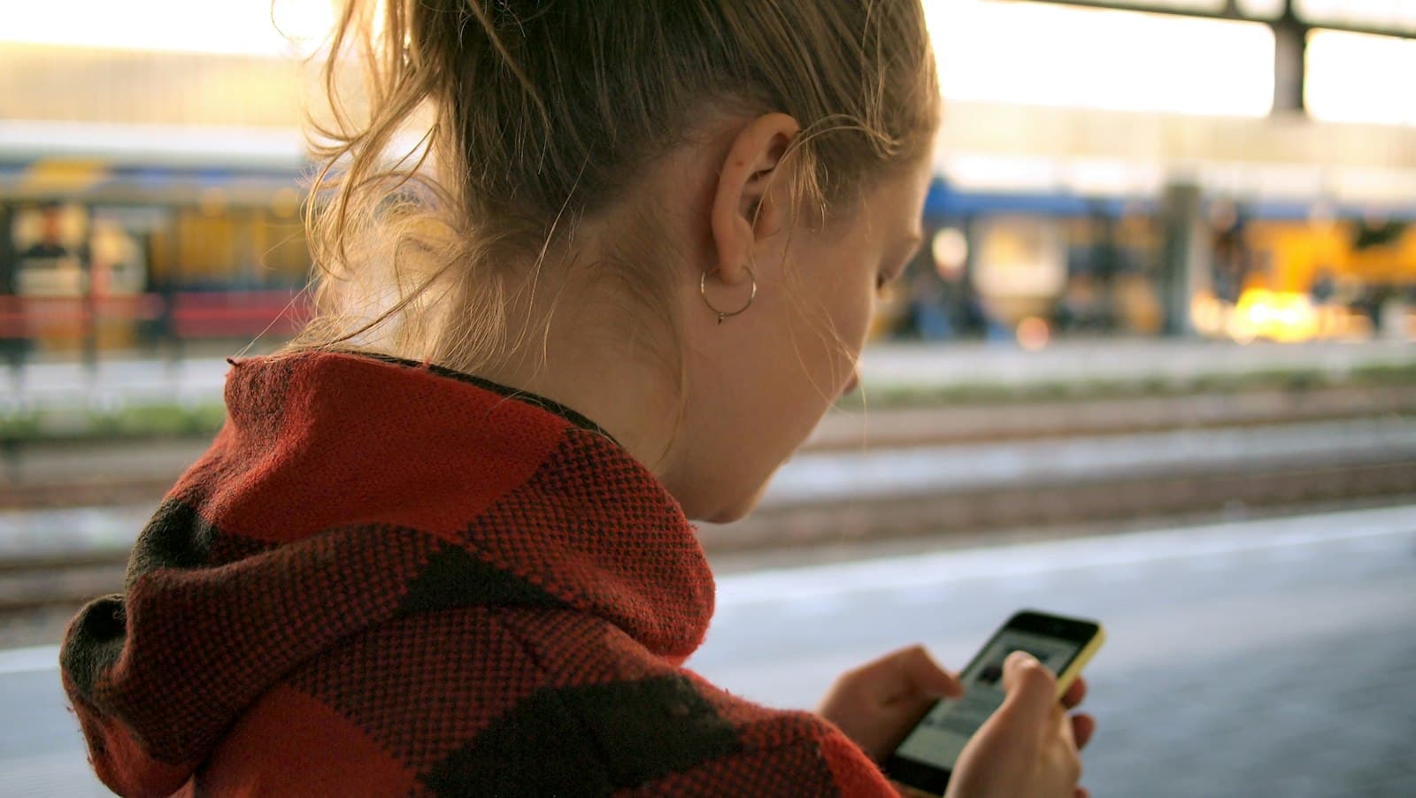 Someone reading on their phone on a morning train.